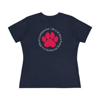 Different Pawspective Women's Premium Tee in Navy. Shown is the back of shirt featuring a large colorful pawprint with the the phrase "Life is all about finding the beauty in a different pawspective" circled around it. The Benefit Beagle Logo is located in the top corner on the front of shirt.