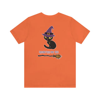 Witchy Cat Unisex Jersey Short Sleeve Tee. Back side shown in Orange with Wide Eyed Cartoon Cat wearing Purple Hat Standing over Broom. "Crossing Paths Since 1692". On the front of shirt is similar Witchy Benefit Beagle Logo. Purrfect for Halloween, or anytime!