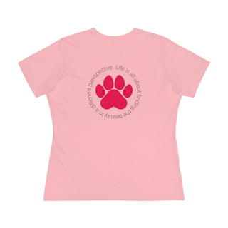 Different Pawspective Women's Premium Tee in Pink. Shown is the back of shirt featuring a large colorful pawprint with the the phrase "Life is all about finding the beauty in a different pawspective" circled around it. The Benefit Beagle Logo is located in the top corner on the front of shirt.
