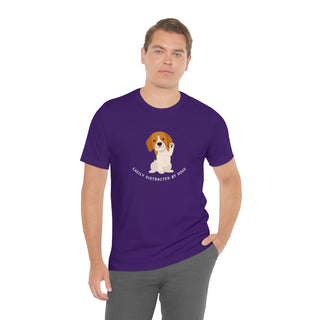 Easily Distracted Unisex Jersey Short Sleeve Tee in Team Purple. Shown is front design featuring a dog waving with the saying "Easily Distracted by Dogs" below it. The back of shirt has the classic Benefit Beagle Logo.