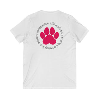 Different Pawspective Unisex V-Neck Tee in White. Shown is the back of shirt featuring a large colorful pawprint with the the phrase "Life is all about finding the beauty in a different pawspective" circled around it. The Benefit Beagle Logo is located in the top corner on the front of shirt.