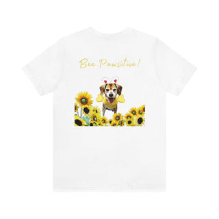 Bee Pawsitive Unisex Jersey Short Sleeve Tee shirt in White. Shown is back of shirt showcasing a dog dressed as as bee in a a field of sunflowers with the phrase "Bee Pawsitive!" above it. The front features the Bee Pawsitive Benefit Beagle Logo.