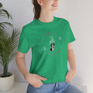 Dog Hair is my Glitter Unisex Jersey Short Sleeve Tee in Heather Kelly. The Dog Hair is my Glitter design features a dog with the phrase "Dog Hair is my Glitter" above it and it is surrounded by a circle with paw prints.