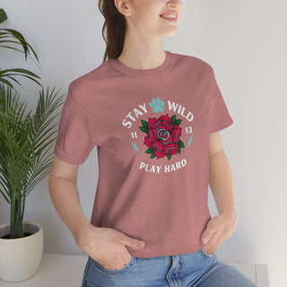 Stay Wild Unisex Premium Tee in Heather Mauve. Shown is front of Stay Wild Design features a tattoo style rose with the phrase "Stay Wild, Play Hard" around it. The back of shirt features the Stay Wild Benefit Beagle Logo Design.