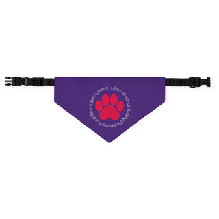 Different Pawspective Dog Collar Bandana in Purple. The Different Pawspective design features the phrase "Life is all about finding the beauty in a different pawspective" around a paw print. Comes with adjustable black collar.