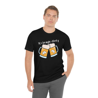 Beagle-Thirty Mugs Unisex Jersey Short Sleeve Tee in Black. The front of shirt showcases Two Dog Adorned Mugs clinking with the saying, "It's Beagle-Thirty" above it. Back of shirt features corresponding Benefit Beagle Logo.