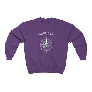 Adventures Await Unisex Crewneck Sweatshirt in Purple. The front of shirt features the Adventures Await design with a dog inside a nautical compass and the words "Adventures Await" above it. The back of the shirt has similar Benefit Beagle Logo.