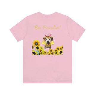 Bee Pawsitive Unisex Jersey Short Sleeve Tee shirt in Pink. Shown is back of shirt showcasing a dog dressed as as bee in a a field of sunflowers with the phrase "Bee Pawsitive!" above it. The front features the Bee Pawsitive Benefit Beagle Logo.