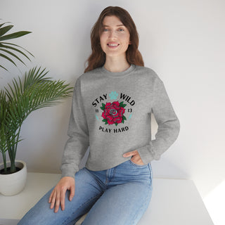 Stay Wild Unisex Heavy Blend Crewneck Sweatshirt in Sport Grey. The Stay Wild Design features a tattoo style rose with the phrase "Stay Wild, Play Hard" around it. The back of shirt features the Stay Wild Benefit Beagle Logo Design.