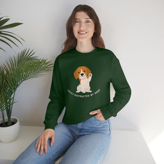 Easily Distracted Unisex Heavy Blend Crewneck Sweatshirt in Forest Green. Shown is front design featuring a dog waving with the saying "Easily Distracted by Dogs" below it. The back of shirt has the classic Benefit Beagle Logo.