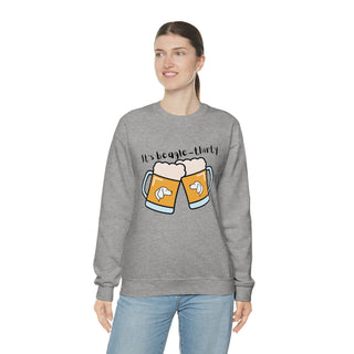 Beagle-Thirty Mugs Unisex Heavy Blend Crewneck Sweatshirt in Sport Grey. The front of shirt showcases Two Dog Adorned Mugs clinking with the saying, "It's Beagle-Thirty" above it. Back of shirt features corresponding Benefit Beagle Logo.