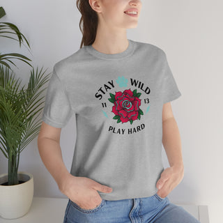 Stay Wild Unisex Premium Tee in Athletic Heather. Shown is front of Stay Wild Design features a tattoo style rose with the phrase "Stay Wild, Play Hard" around it. The back of shirt features the Stay Wild Benefit Beagle Logo Design.