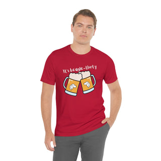 Beagle-Thirty Mugs Unisex Jersey Short Sleeve Tee in Red. The front of shirt showcases Two Dog Adorned Mugs clinking with the saying, "It's Beagle-Thirty" above it. Back of shirt features corresponding Benefit Beagle Logo.