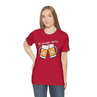 Beagle-Thirty Mugs Unisex Jersey Short Sleeve Tee in Red. The front of shirt showcases Two Dog Adorned Mugs clinking with the saying, "It's Beagle-Thirty" above it. Back of shirt features corresponding Benefit Beagle Logo.