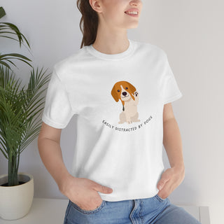 Easily Distracted Unisex Jersey Short Sleeve Tee in White. Shown is front design featuring a dog waving with the saying "Easily Distracted by Dogs" below it. The back of shirt has the classic Benefit Beagle Logo.