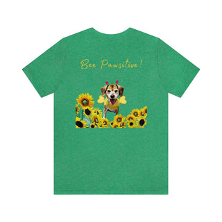 Bee Pawsitive Unisex Jersey Short Sleeve Tee shirt  in Heather Kelly. Shown is back of shirt showcasing a dog dressed as as bee in a a field of sunflowers with the phrase "Bee Pawsitive!" above it. The front features the Bee Pawsitive Benefit Beagle Logo.