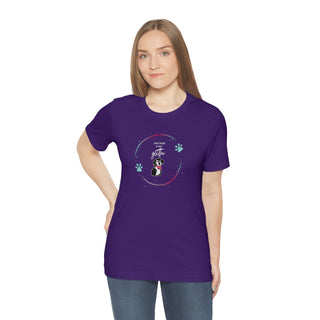 Dog Hair is my Glitter Unisex Jersey Short Sleeve Tee in Team Purple. The Dog Hair is my Glitter design features a dog with the phrase "Dog Hair is my Glitter" above it and it is surrounded by a circle with paw prints.