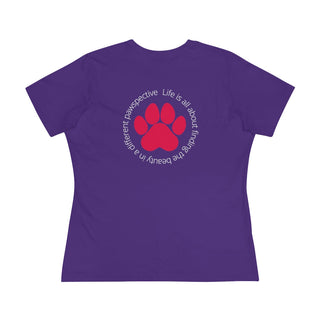 Different Pawspective Women's Premium Tee in Purple. Shown is the back of shirt featuring a large colorful pawprint with the the phrase "Life is all about finding the beauty in a different pawspective" circled around it. The Benefit Beagle Logo is located in the top corner on the front of shirt.