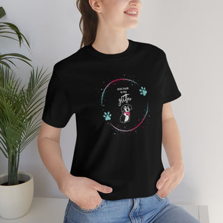 Dog Hair is my Glitter Unisex Jersey Short Sleeve Tee in Black. The Dog Hair is my Glitter design features a dog with the phrase "Dog Hair is my Glitter" above it and it is surrounded by a circle with paw prints.