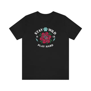 Stay Wild Unisex Premium Tee in Black. Shown is front of Stay Wild Design features a tattoo style rose with the phrase "Stay Wild, Play Hard" around it. The back of shirt features the Stay Wild Benefit Beagle Logo Design.