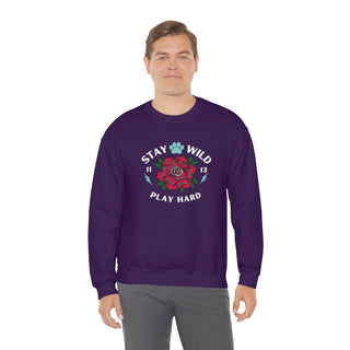 Stay Wild Unisex Heavy Blend Crewneck Sweatshirt in Purple. The Stay Wild Design features a tattoo style rose with the phrase "Stay Wild, Play Hard" around it. The back of shirt features the Stay Wild Benefit Beagle Logo Design.