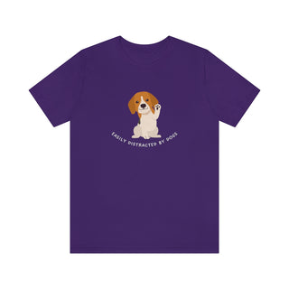 Easily Distracted Unisex Jersey Short Sleeve Tee in Team Purple. Shown is front design featuring a dog waving with the saying "Easily Distracted by Dogs" below it. The back of shirt has the classic Benefit Beagle Logo.