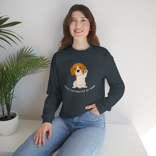 Easily Distracted Unisex Heavy Blend Crewneck Sweatshirt in Dark Heather. Shown is front design featuring a dog waving with the saying "Easily Distracted by Dogs" below it. The back of shirt has the classic Benefit Beagle Logo.