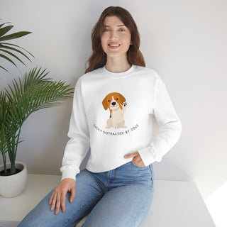 Easily Distracted Unisex Heavy Blend Crewneck Sweatshirt in White. Shown is front design featuring a dog waving with the saying "Easily Distracted by Dogs" below it. The back of shirt has the classic Benefit Beagle Logo.