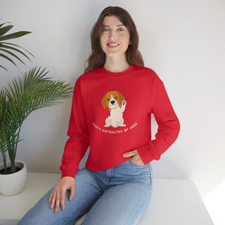 Easily Distracted Unisex Heavy Blend Crewneck Sweatshirt in Red. Shown is front design featuring a dog waving with the saying "Easily Distracted by Dogs" below it. The back of shirt has the classic Benefit Beagle Logo.