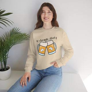 Beagle-Thirty Mugs Unisex Heavy Blend Crewneck Sweatshirt in Sand. The front of shirt showcases Two Dog Adorned Mugs clinking with the saying, "It's Beagle-Thirty" above it. Back of shirt features corresponding Benefit Beagle Logo.