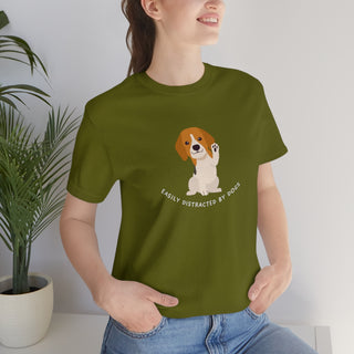 Easily Distracted Unisex Jersey Short Sleeve Tee in Olive. Shown is front design featuring a dog waving with the saying "Easily Distracted by Dogs" below it. The back of shirt has the classic Benefit Beagle Logo.