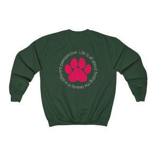 Different Pawspective Unisex Crewneck Sweatshirt in Forest Green. Shown is the back of shirt featuring a large colorful pawprint with the the phrase "Life is all about finding the beauty in a different pawspective" circled around it. The Benefit Beagle Logo is located in the top corner on the front of shirt.