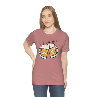 Beagle-Thirty Mugs Unisex Jersey Short Sleeve Tee in Heather Mauve. The front of shirt showcases Two Dog Adorned Mugs clinking with the saying, "It's Beagle-Thirty" above it. Back of shirt features corresponding Benefit Beagle Logo.