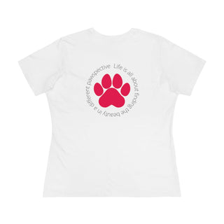 Different Pawspective Women's Premium Tee in White. Shown is the back of shirt featuring a large colorful pawprint with the the phrase "Life is all about finding the beauty in a different pawspective" circled around it. The Benefit Beagle Logo is located in the top corner on the front of shirt.