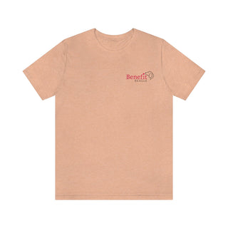 Different Pawspective Unisex Jersey Short Sleeve Tee in Heather Peach. Shown is front of shirt with Benefit Beagle logo in the top corner . On the back is large colorful pawprint with the the phrase "Life is all about finding the beauty in a different pawspective" circled around it.