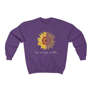 You are my Sunshine Unisex Crewneck Sweatshirt in Purple. Shown is the front showcasing a sunflower which is split down the middle and half is made out of paw prints. Underneath is the phrase "You are my Sunshine" . Back of shirt features the Sunflower Benefit Beagle Logo.