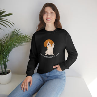 Easily Distracted Unisex Heavy Blend Crewneck Sweatshirt in Black. Shown is front design featuring a dog waving with the saying "Easily Distracted by Dogs" below it. The back of shirt has the classic Benefit Beagle Logo.