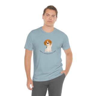 Easily Distracted Unisex Jersey Short Sleeve Tee in Light Blue. Shown is front design featuring a dog waving with the saying "Easily Distracted by Dogs" below it. The back of shirt has the classic Benefit Beagle Logo.