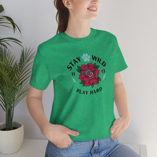 Stay Wild Unisex Premium Tee in Heather Kelly. Shown is front of Stay Wild Design features a tattoo style rose with the phrase "Stay Wild, Play Hard" around it. The back of shirt features the Stay Wild Benefit Beagle Logo Design.