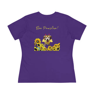 Bee Pawsitive Women's Premium Tee in Team Purple. Shown is back of shirt showcasing a dog dressed as as bee in a a field of sunflowers with the phrase "Bee Pawsitive!" above it. The front features the Bee Pawsitive Benefit Beagle Logo.