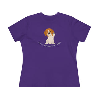 Easily Distracted Women's Premium Tee in Team Purple. Shown is front design featuring a dog waving with the saying "Easily Distracted by Dogs" below it. The back of shirt has the classic Benefit Beagle Logo.