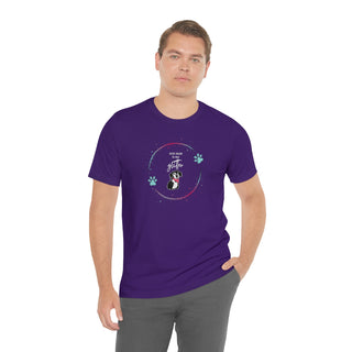 Dog Hair is my Glitter Unisex Jersey Short Sleeve Tee in Team Purple. The Dog Hair is my Glitter design features a dog with the phrase "Dog Hair is my Glitter" above it and it is surrounded by a circle with paw prints.