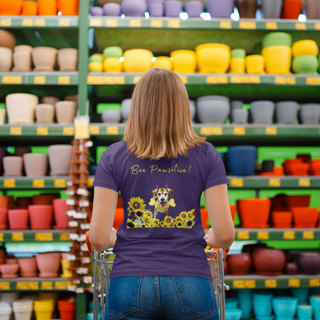 Bee Pawsitive Women's Premium Tee in Team Purple. Shown is back of shirt showcasing a dog dressed as as bee in a a field of sunflowers with the phrase "Bee Pawsitive!" above it. The front features the Bee Pawsitive Benefit Beagle Logo.