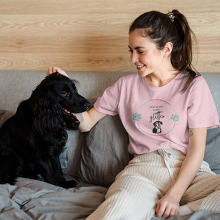 Dog Hair is my Glitter Unisex Jersey Short Sleeve Tee in pink. The Dog Hair is my Glitter design features a dog with the phrase "Dog Hair is my Glitter" above it and it is surrounded by a circle with paw prints.