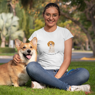 Easily Distracted Women's Premium Tee in White. Shown is front design featuring a dog waving with the saying "Easily Distracted by Dogs" below it. The back of shirt has the classic Benefit Beagle Logo.