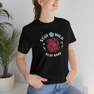 Stay Wild Unisex Premium Tee in Black. Shown is front of Stay Wild Design features a tattoo style rose with the phrase "Stay Wild, Play Hard" around it. The back of shirt features the Stay Wild Benefit Beagle Logo Design.