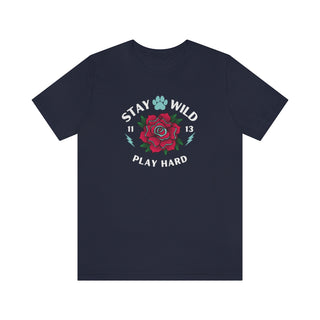 Stay Wild Unisex Premium Tee in Navy. Shown is front of Stay Wild Design features a tattoo style rose with the phrase "Stay Wild, Play Hard" around it. The back of shirt features the Stay Wild Benefit Beagle Logo Design.