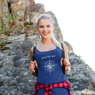 Adventures Await Women's Racerback Tank in True Royal. The front of shirt features the Adventures Await design with a dog inside a nautical compass and the words "Adventures Await" above it. The back of the shirt has similar Benefit Beagle Logo.