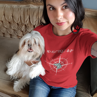 Adventures Await Women's Softstyle Tee in Red. The front of shirt features the Adventures Await design with a dog inside a nautical compass and the words "Adventures Await" above it. The back of the shirt has similar Benefit Beagle Logo.