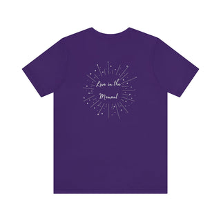 Live in the Moment Unisex Short Sleeve Tee in Purple. The Live in the Moment design features a graphic on the back with the phrase "Live in the Moment" surrounded by shooting stars.